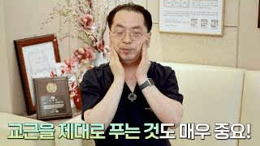이원장이 양쪽 교근 부위를 손바닥으로 부드럽게 푸는 방법을 설명하는 영상 장면